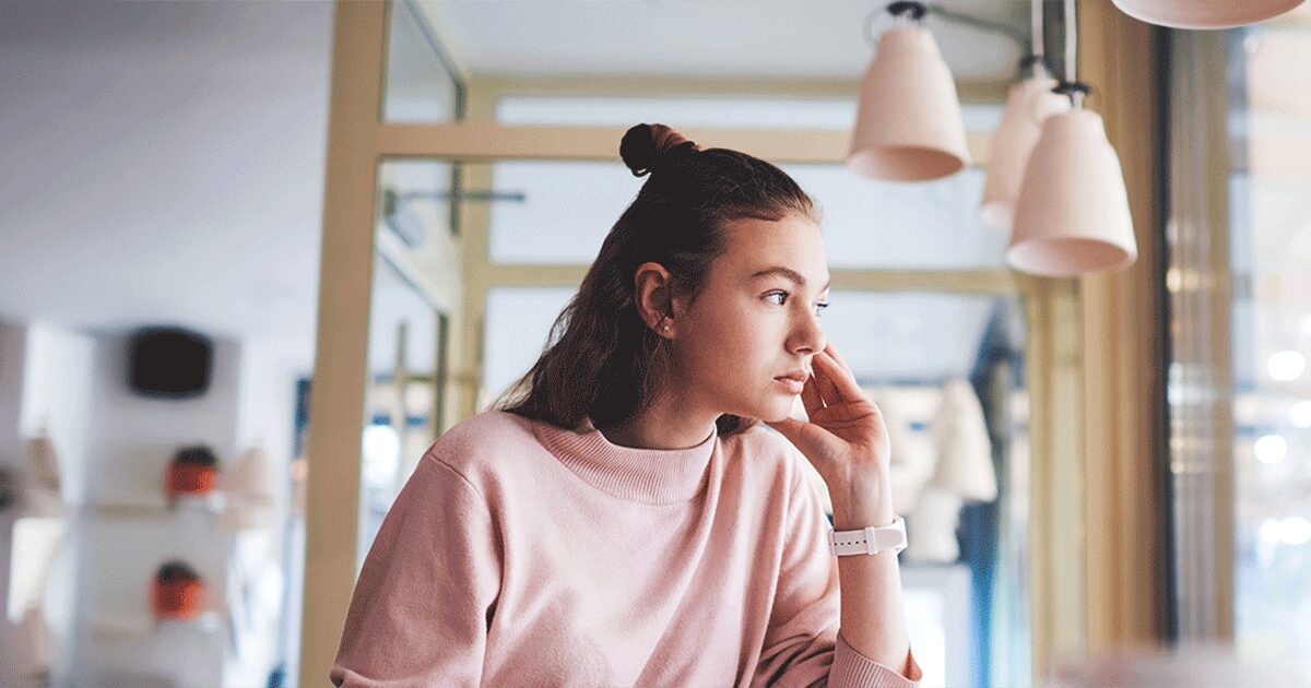 Woman looking out a window while learning about warning signs of infection after abortion.